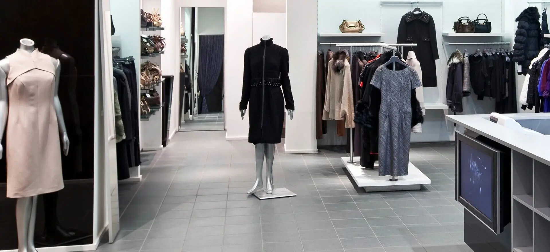 A mannequin in a store with clothes on display.