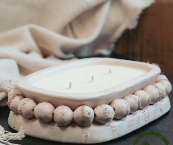 A candle is sitting in a bowl on top of a table.