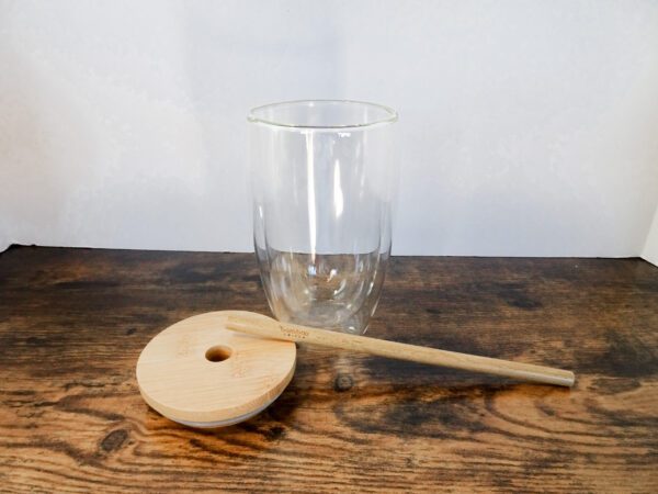 A wooden spoon and glass on the table.