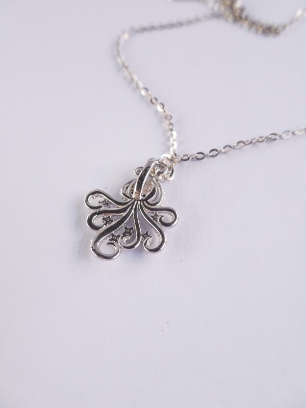 A silver necklace with an octopus on it.