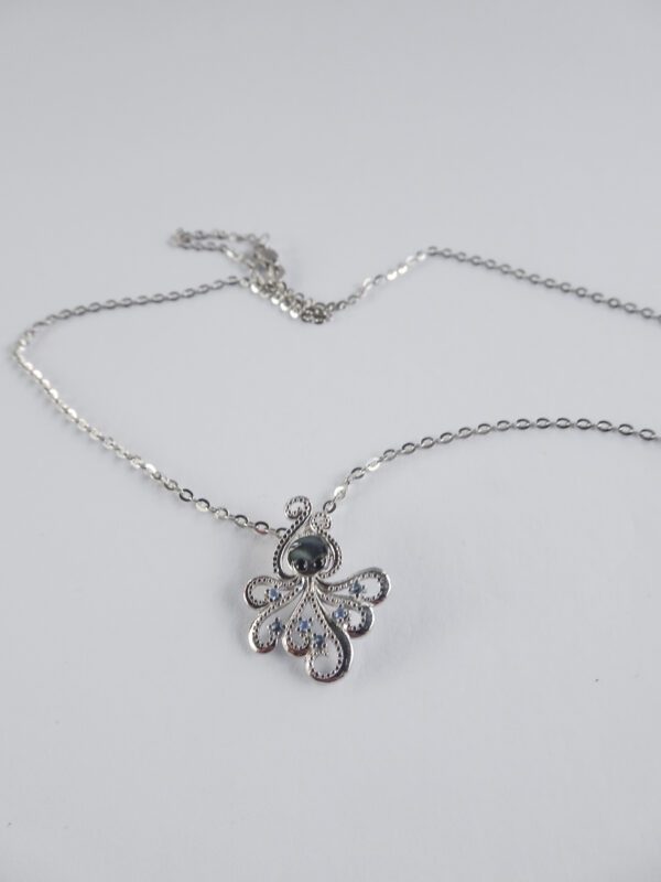 A silver necklace with an octopus on it.