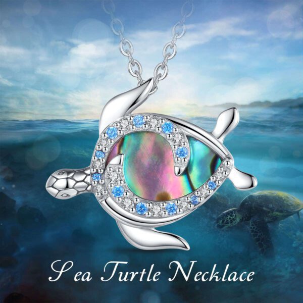 A sea turtle necklace with blue and white crystals