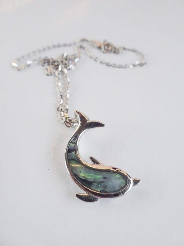 A silver necklace with a dolphin shaped pendant.