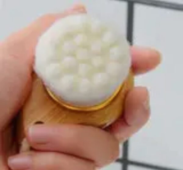 A person holding a toothbrush with white bristles.