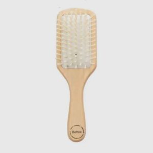 A wooden paddle brush with white bristles.