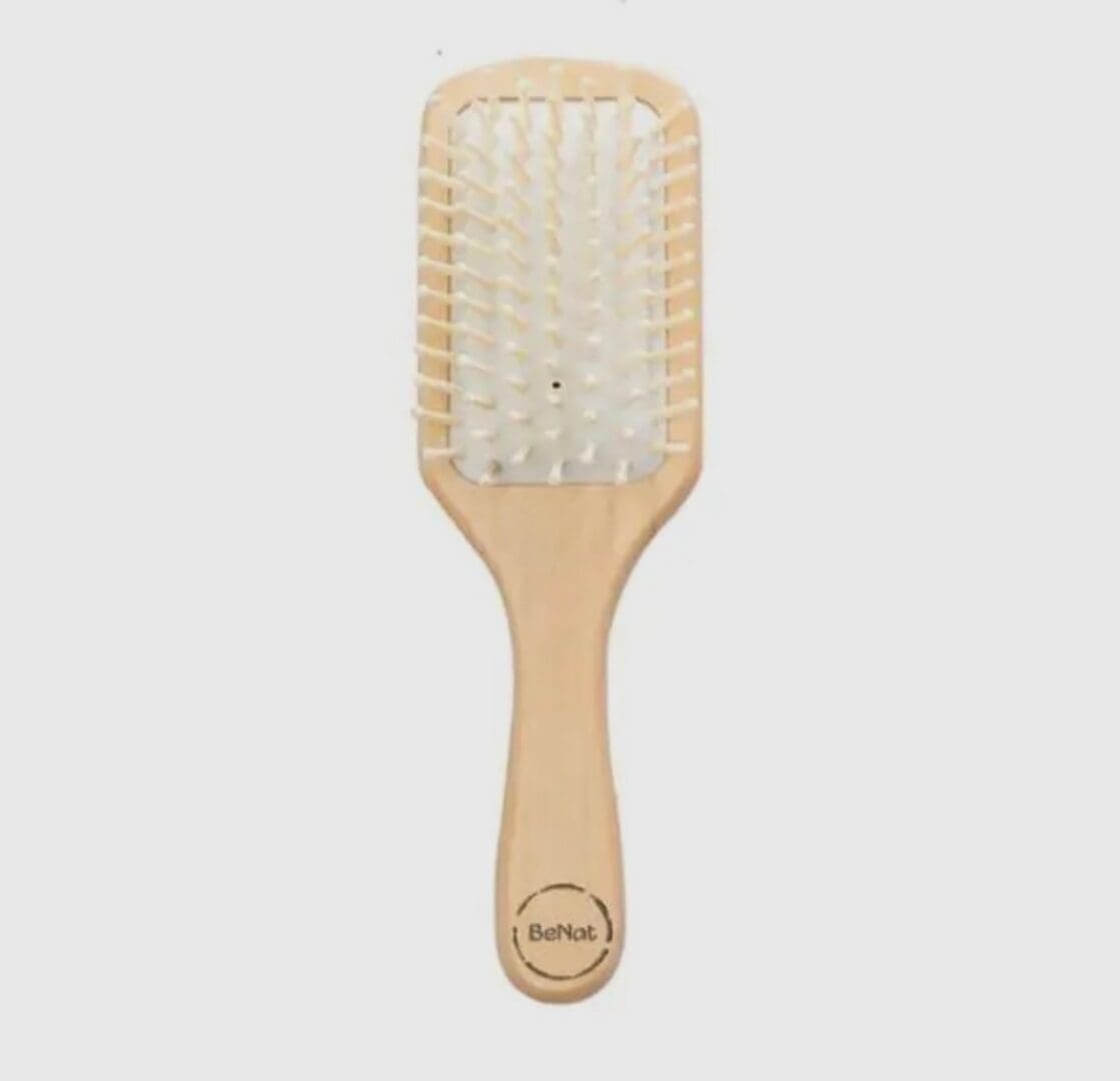 A wooden paddle brush with white bristles.