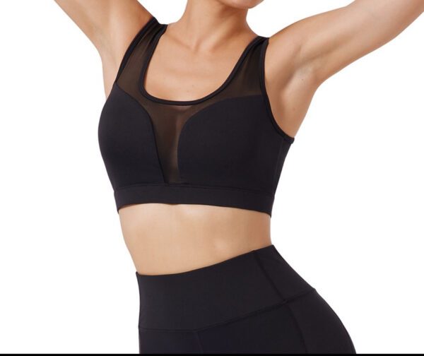 A woman wearing black sports bra and leggings.