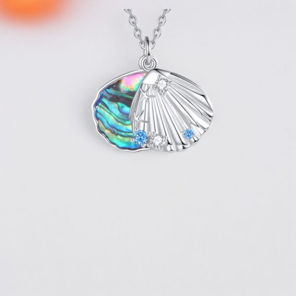 A shell shaped necklace with an abalone shell on it.