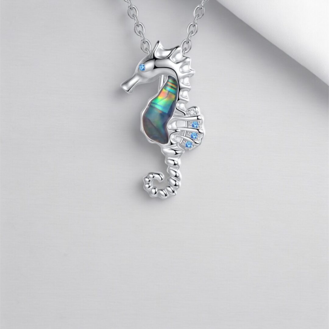 A silver necklace with an ocean themed piece of jewelry.