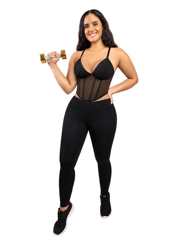 A woman in black and white outfit holding a dumbbell.