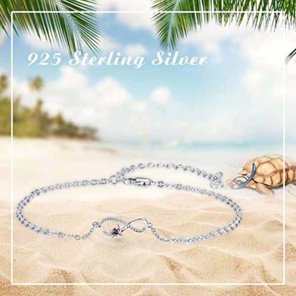 A silver anklet on the beach with a palm tree in the background.