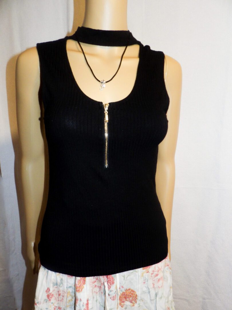 A black tank top with a necklace hanging from it.