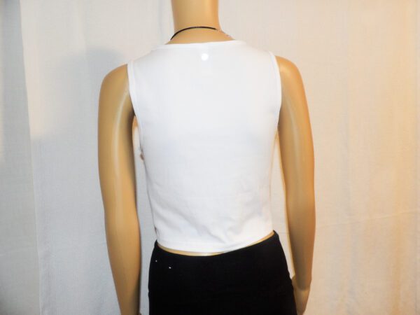 A mannequin wearing a white tank top and black pants.