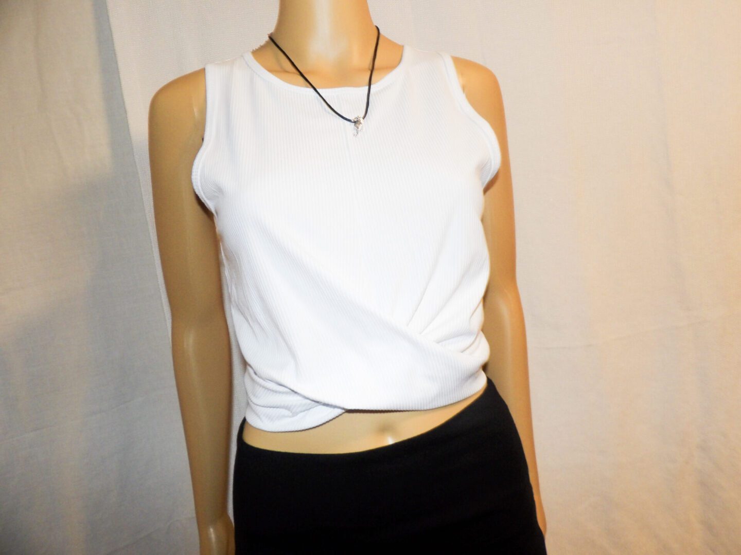 A mannequin wearing a white top and black skirt.