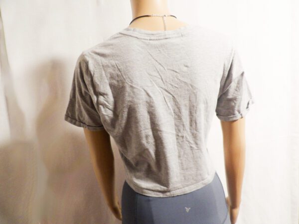 A mannequin wearing a gray shirt and blue pants.