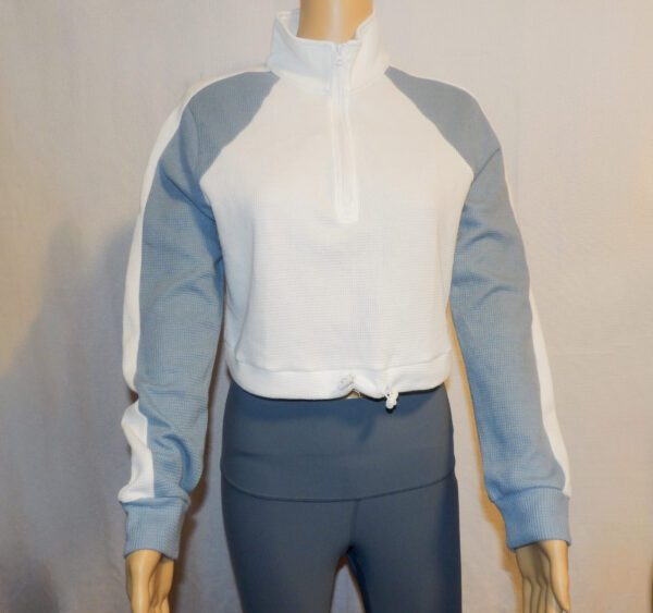 A mannequin wearing a white and blue jacket.