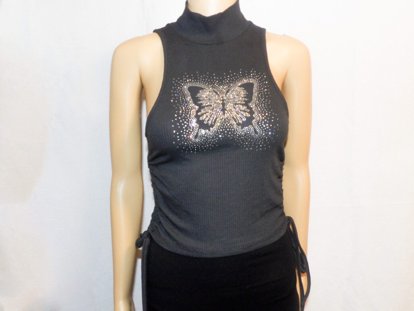 A woman wearing a black top with a butterfly on it.