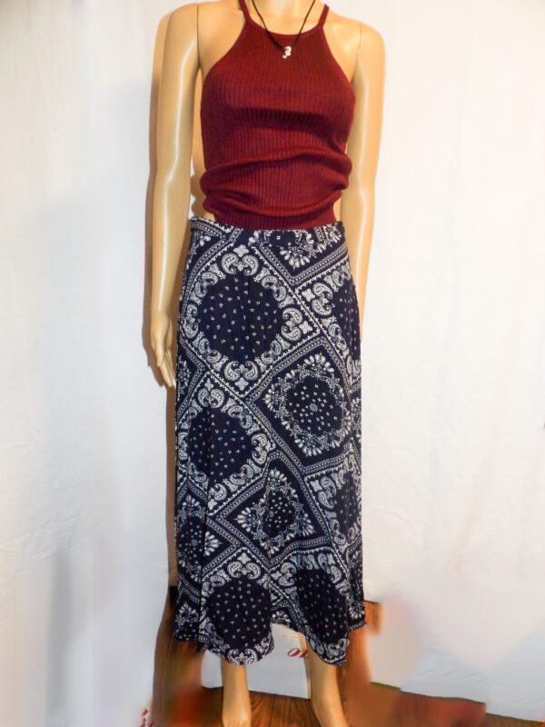 A mannequin wearing a long skirt with a red top.