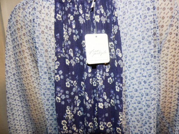 A blue and white floral print dress hanging on the wall.
