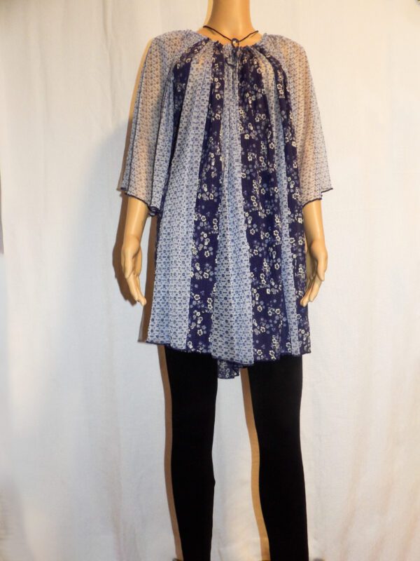 A mannequin wearing black pants and a blue dress.