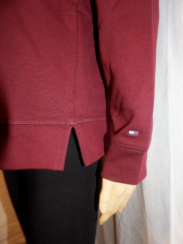 A close up of the sleeve and pocket on a red jacket.