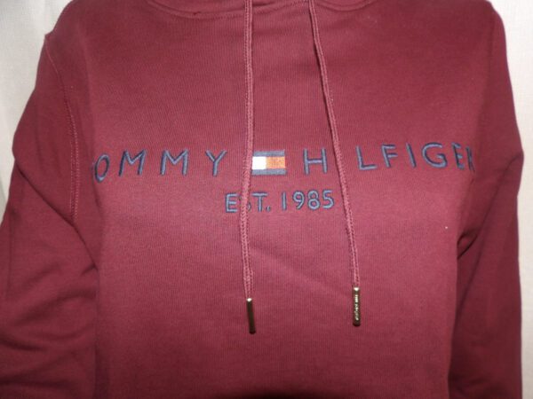 A close up of the front of a red tommy hilfiger hoodie