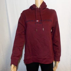 A woman wearing a maroon sweatshirt with black pants.