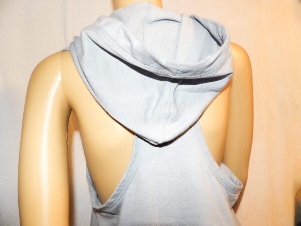 A mannequin wearing a gray hooded top with open back.