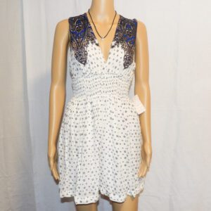 A white dress with black polka dots and a blue lace collar.