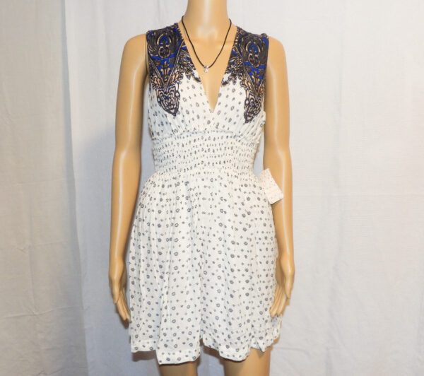 A white dress with black polka dots and a blue lace collar.