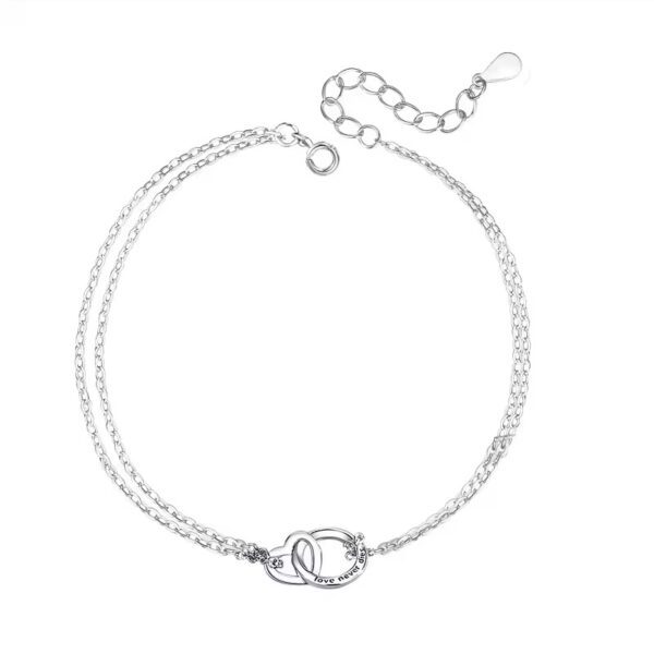 A silver chain bracelet with two handcuffs on it.