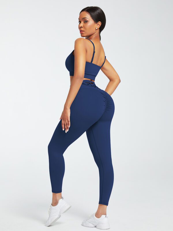 A woman in blue workout clothes is posing for the camera.