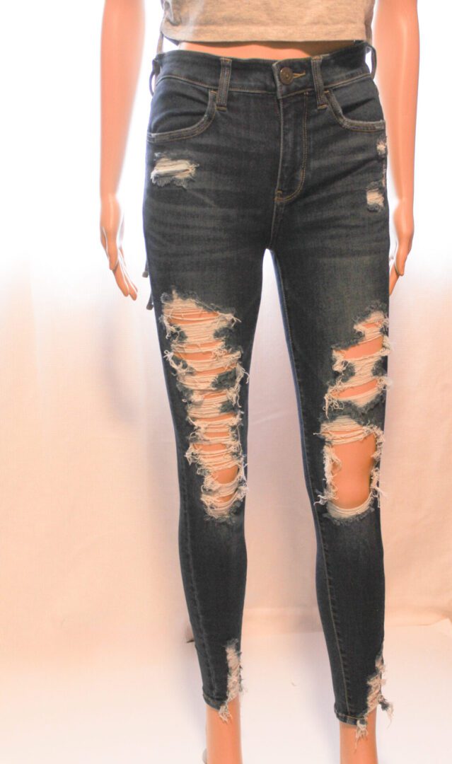 A woman wearing ripped jeans and standing up.