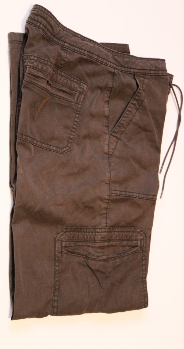 A pair of brown cargo pants hanging on a wall.