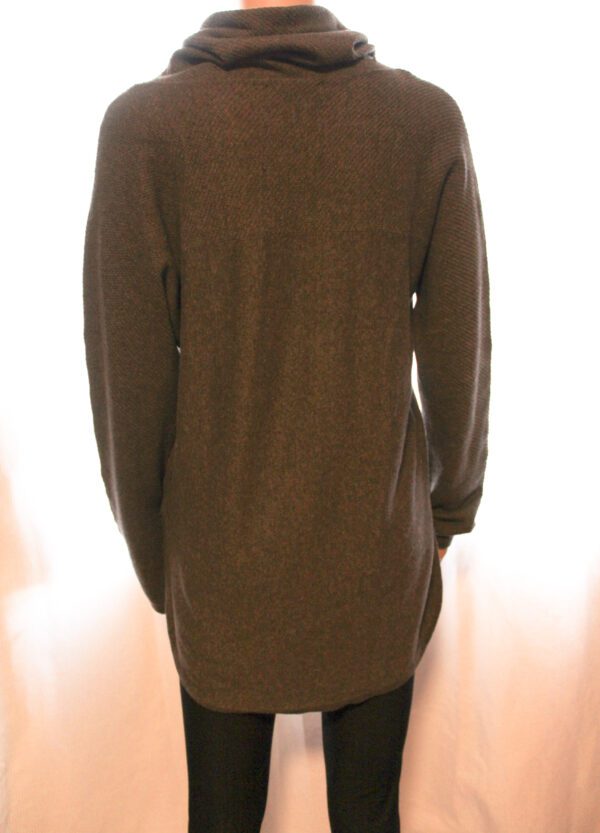 A person wearing a brown sweater and black pants.