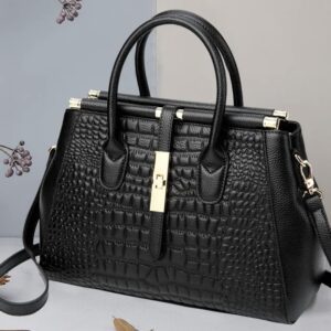 A black purse with gold hardware and a strap.