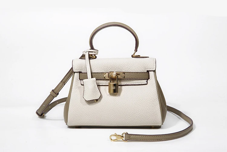 A white and green handbag with a strap.