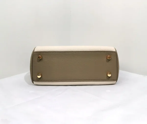 A tan purse sitting on top of a white table.