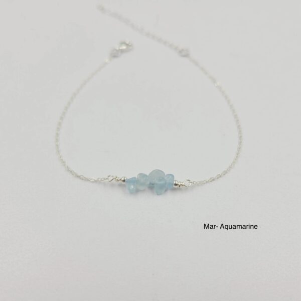 A silver bracelet with a blue stone on it.