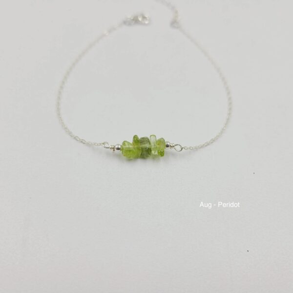 A green bead necklace on a white string.