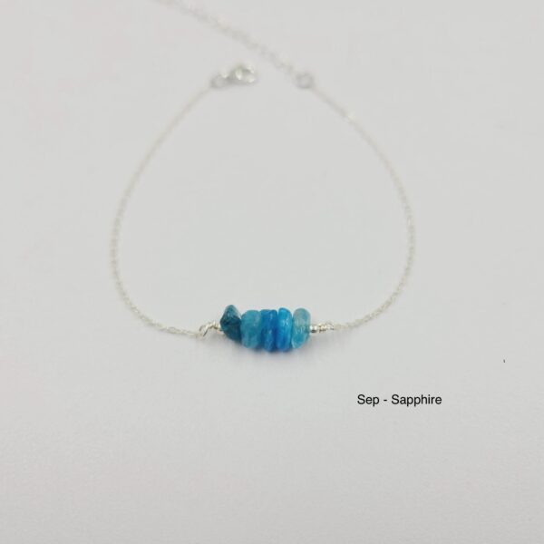 A blue necklace with silver chain and three beads.