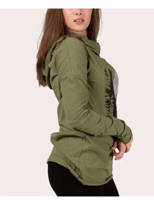 A woman wearing a green jacket and black pants.