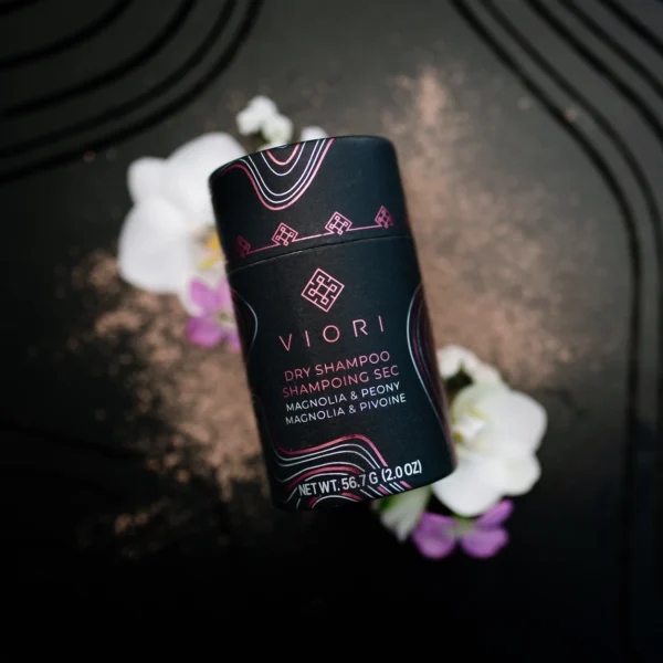 A bottle of vioni deodorant sitting on top of some flowers.