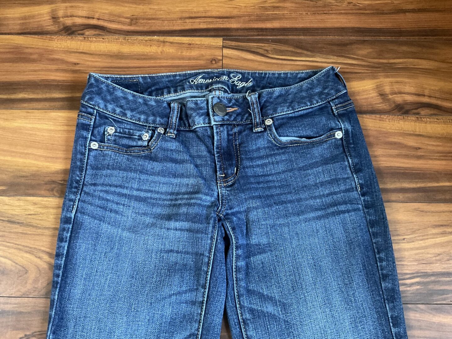 A close up of the waist and front pockets on a pair of jeans.