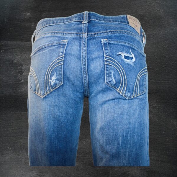 A pair of blue jeans with holes and patches.