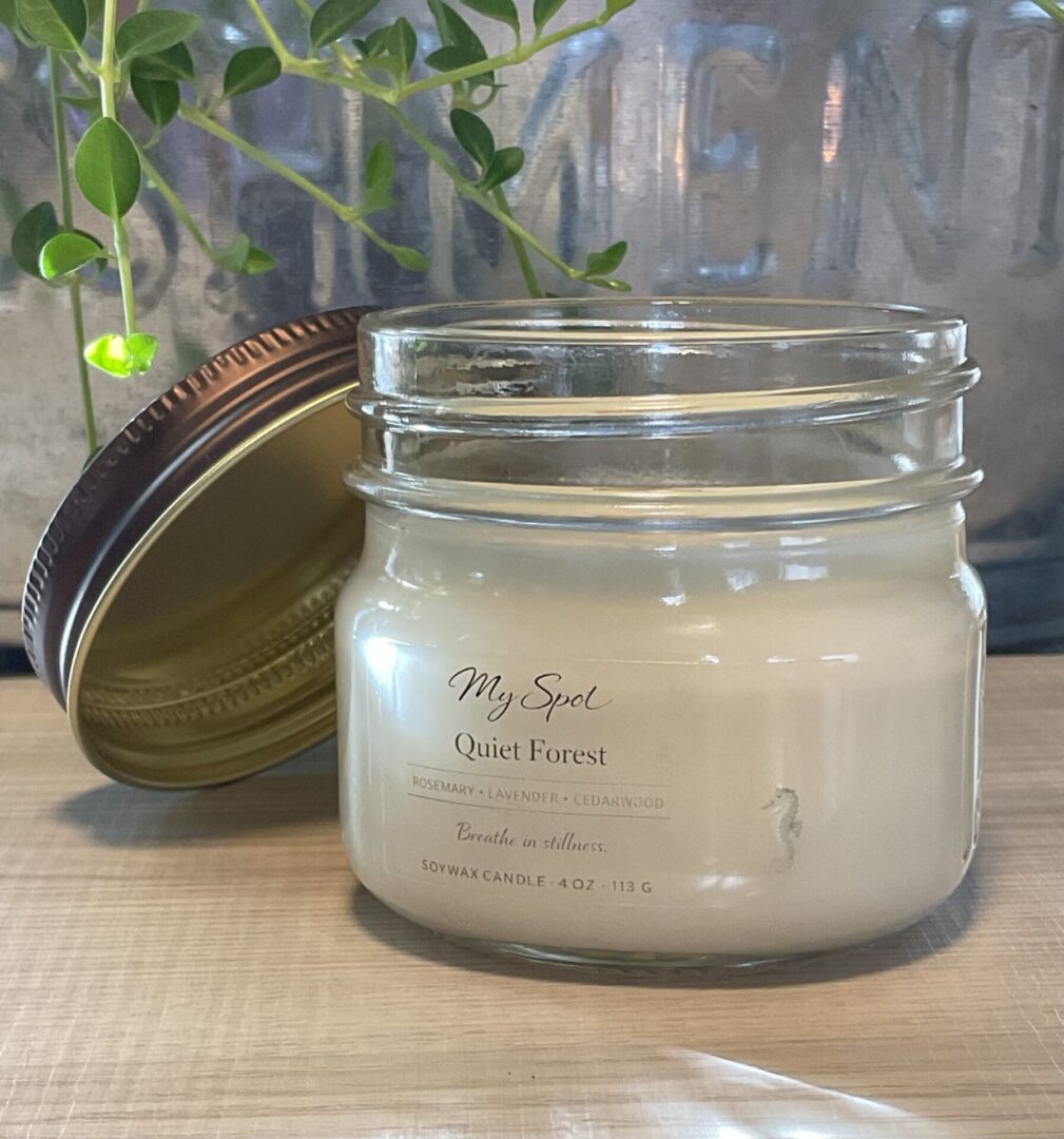 handmade soy candle quiet forest in open glass jar with natural greenery
